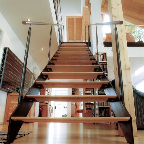 Die gerade Treppe mit balligen Holzstufen leicht und transparent.